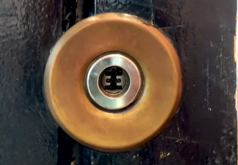 Cilindro de seguridad con escudo protector en una puerta